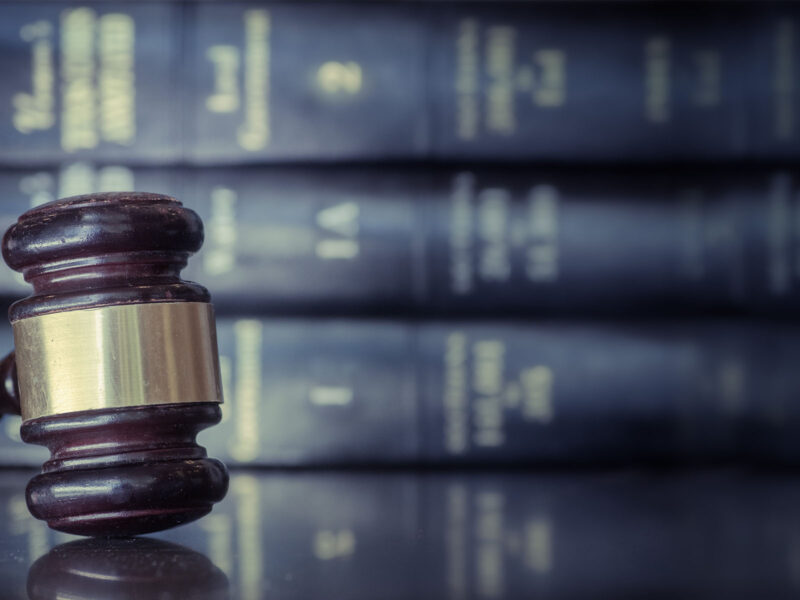 Hammer on table with books behind